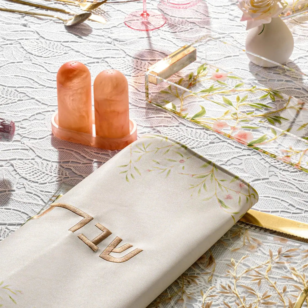 Amber resin salt shaker set with matching tray displayed on white patterned fabric, featuring elegant modern design for tabletop use.