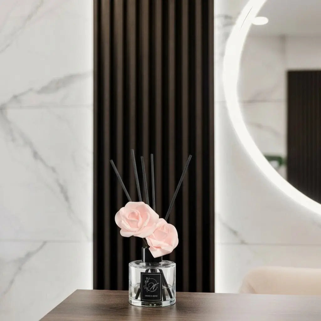 Blush Bloom Diffuser by Waterdale Collection displayed with peach flowers in a black vase on marble surface