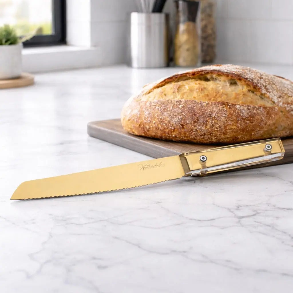 Waterdale Classic Bread Knife with serrated blade next to sliced loaf on marble countertop, wooden handle visible