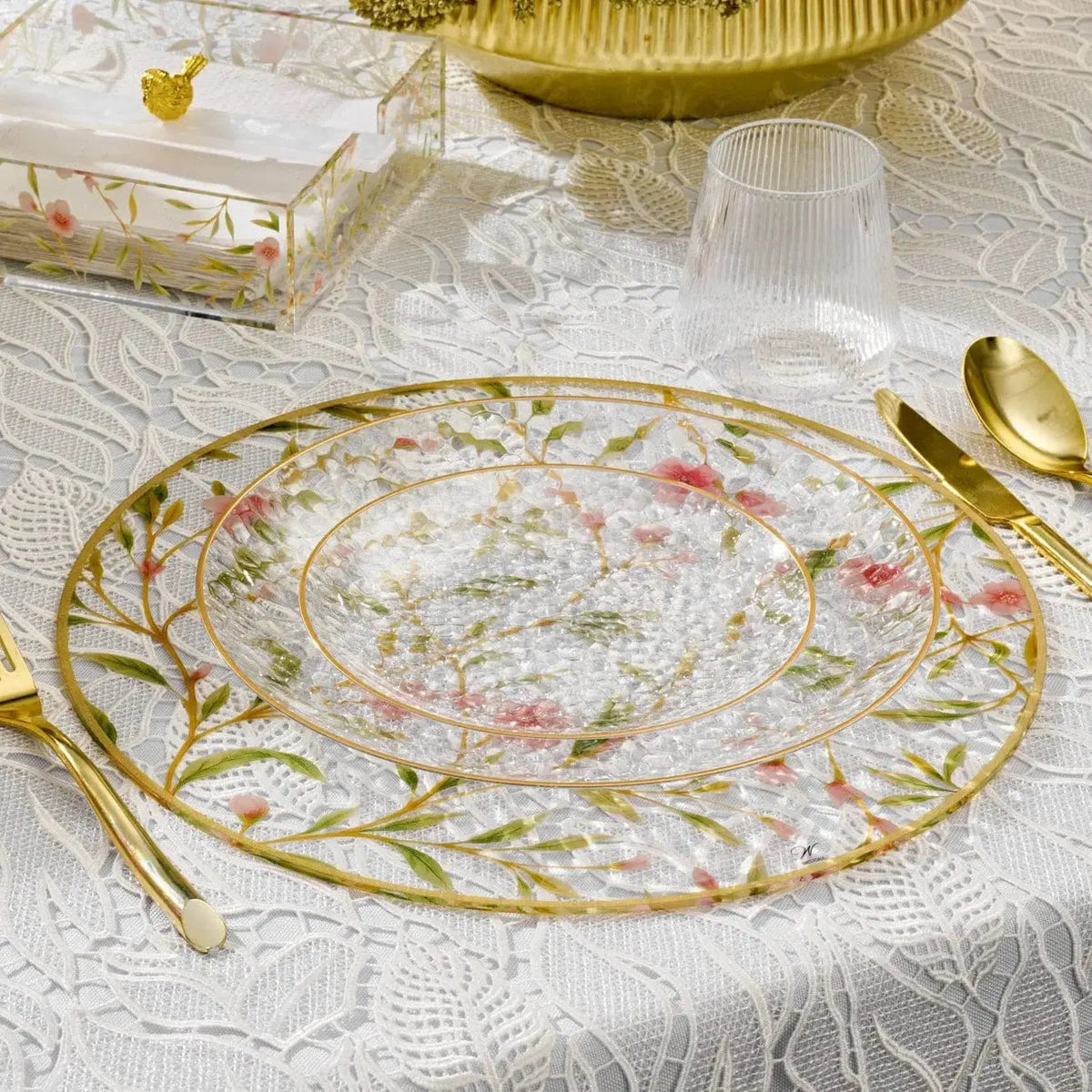Floral Bird Charger plate with delicate pink and green botanical design on cream background, featuring gold rim and matching gold utensils on white damask tablecloth.