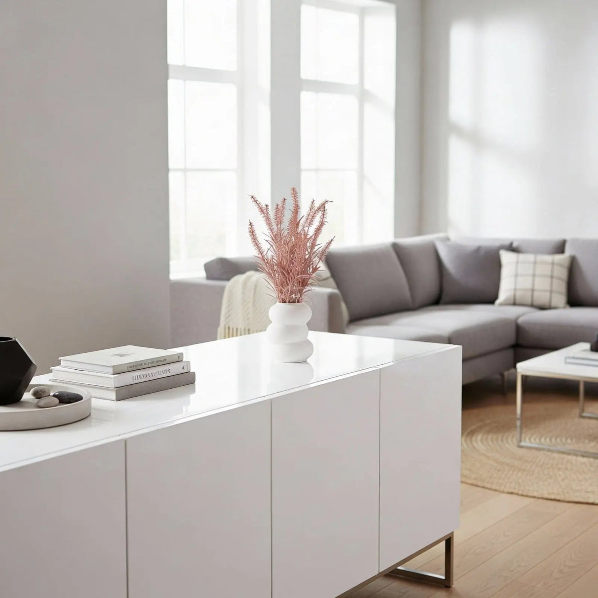 White faux floral donut vase by Waterdale Collection displayed on a modern console table in a bright living room setting.