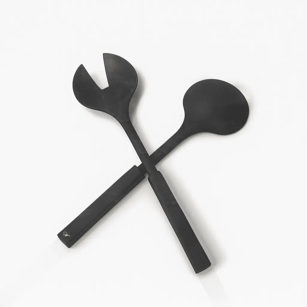 Pair of black resin salad servers with crossed handles and rounded serving ends, elegant serveware for entertaining and special occasions.