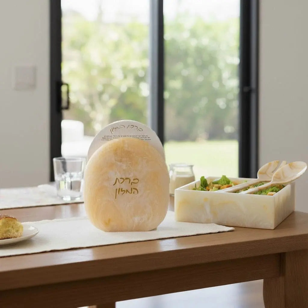 Gold glitter resin salad servers by Waterdale Collection displayed on a wooden countertop with tableware and greenery in background.