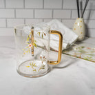 Floral Bird Washing Cup in cream with gold accents, ceramic design with matching dish, perfect for Shabbat and holiday gifting.