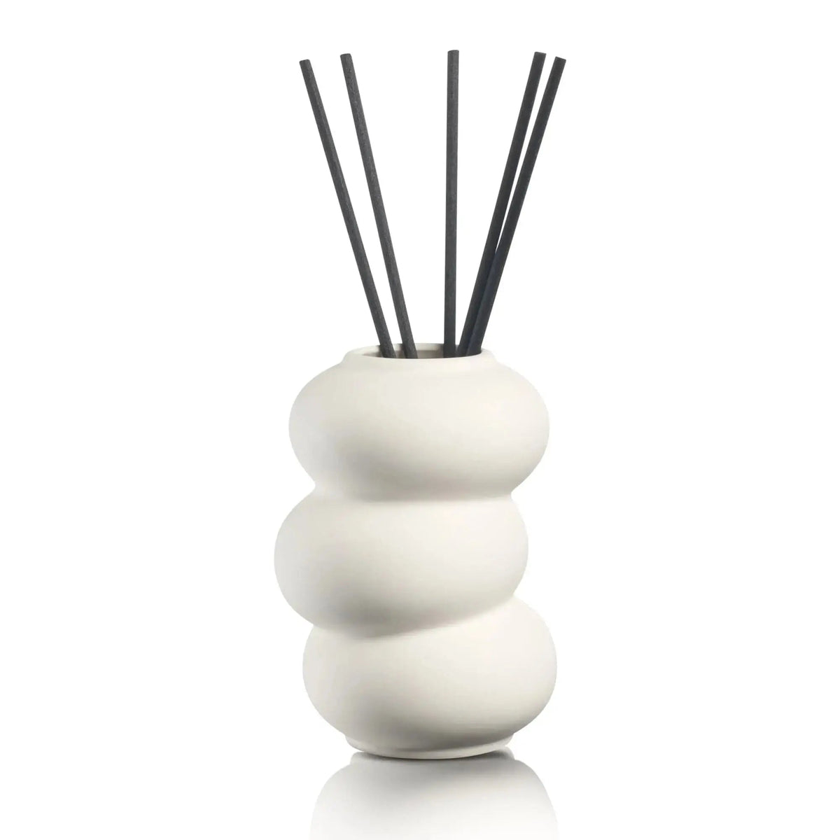Stacked white ceramic donut-shaped reed diffuser with black rattan sticks by Waterdale Collection, modern home fragrance decor.
