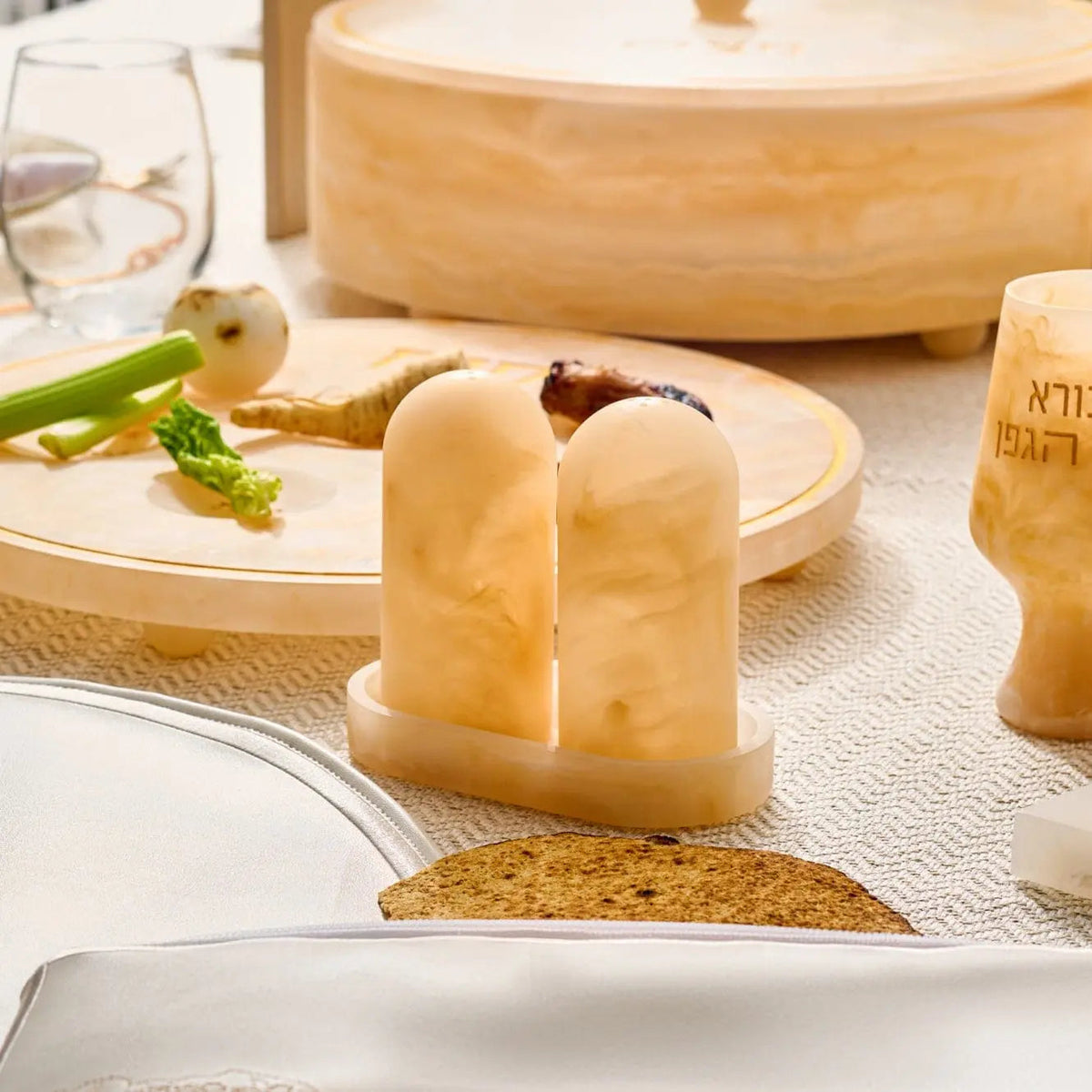 Amber resin salt shaker set with matching tray on wooden surface, featuring translucent honey-colored design ideal for table settings and entertaining.