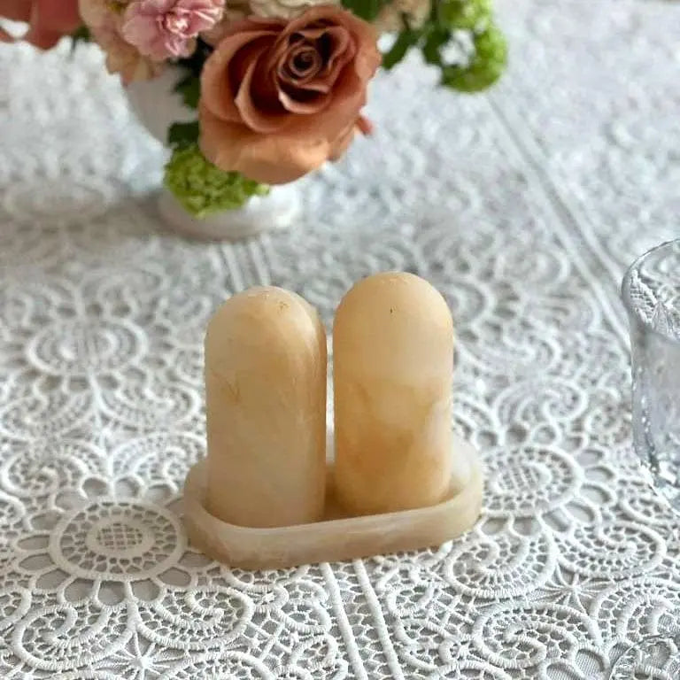 Resin salt shaker set with matching tray in light blue, displayed on lace tablecloth with fresh roses