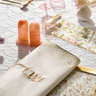 Amber resin salt shaker set with matching tray displayed on white patterned fabric, featuring elegant modern design for tabletop use.