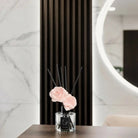 Blush Bloom Diffuser by Waterdale Collection displayed with peach flowers in a black vase on marble surface
