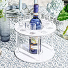 Classic round liquor set with white marble base and blue glass bottle, displayed with matching glasses on decorative surface