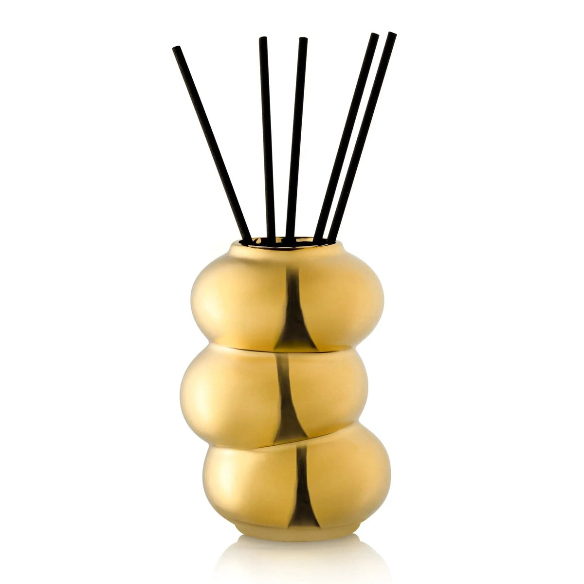 Stacked gold donut-shaped reed diffuser with black rattan sticks by Waterdale Collection, a stylish home fragrance accent.