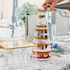 Mixed metallic wine decanter with gold and copper accents displayed on kitchen counter with wine glasses nearby