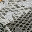 Onyx Butterfly Tablecloth in white leather mesh with embroidered butterfly motifs throughout the fabric pattern.