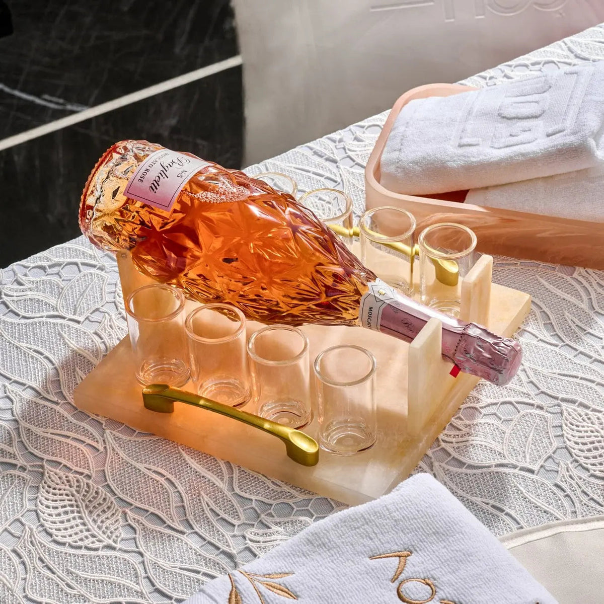 Amber resin liquor and wine serving set with golden accents and decorative bottles, displayed on white marble surface for Shabbat and holiday entertaining.