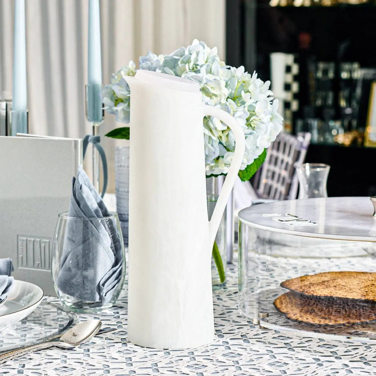 White resin pitcher from Waterdale Collection displayed with flowers and table settings, elegant tabletop decor piece.