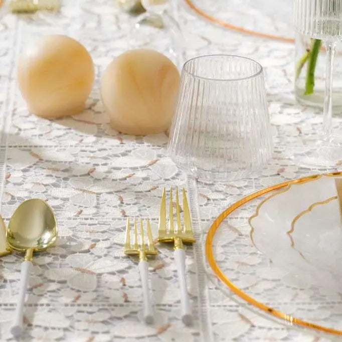 Pair of translucent amber resin salt shakers displayed on a marble table setting with gold-rimmed dinnerware and glassware.