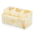 Cream-colored resin silverware caddy with four compartments for organizing utensils on a dining table.