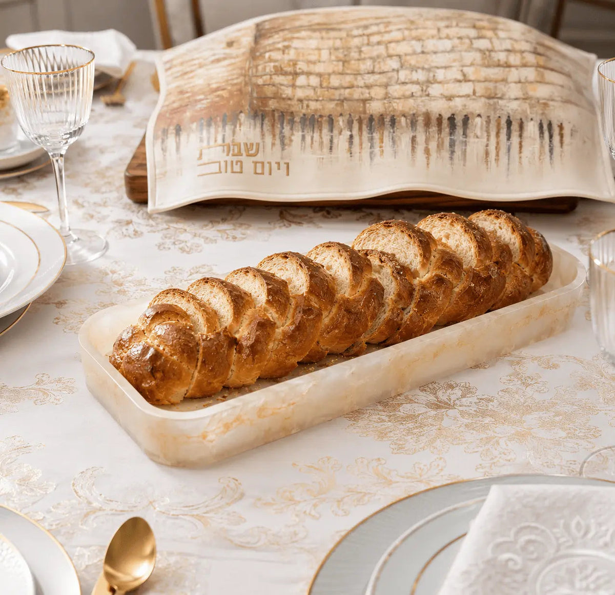 Waterdale Collection resin bread tray displaying sliced loaf on marble table with place settings and water glass nearby