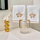 Stacked Bubble Flower Diffuser in clear glass with gold accents, displayed with white towels and decorative gold spheres on a white surface.