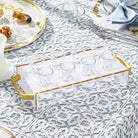 Suspended Pearlstone Liquor Set with white marble tray, gold metal frame, and drinking glasses arranged on patterned tablecloth for Shabbat entertaining.